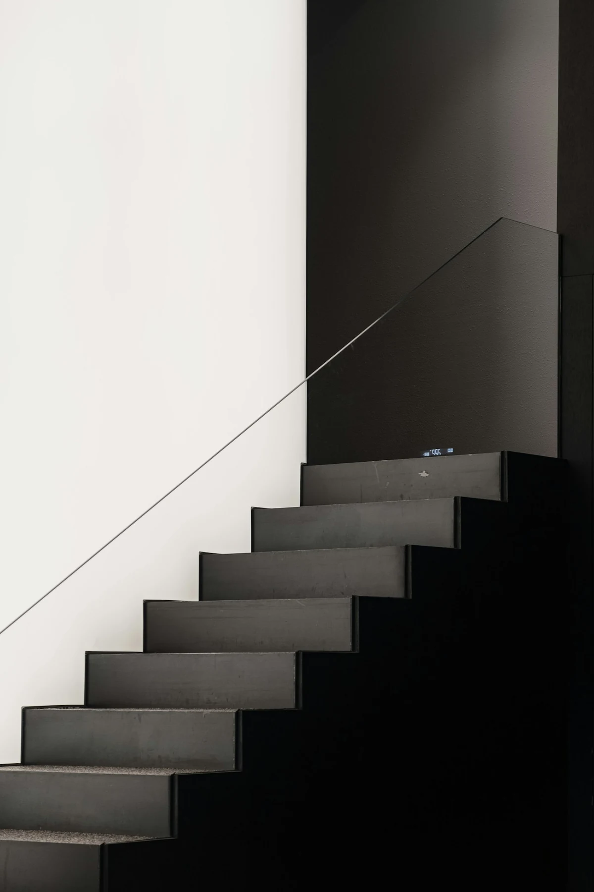 Escalier métallique suspendu, structure noire minimaliste